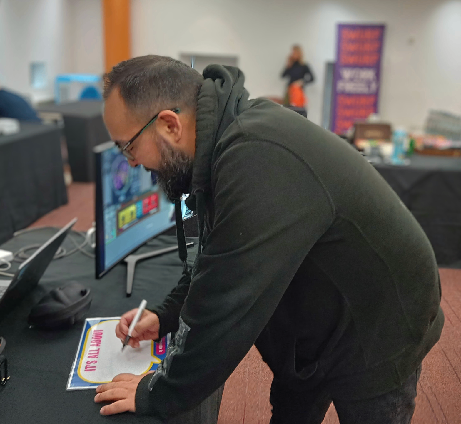 An attendee jotting down a quick reaction on a Yush sign